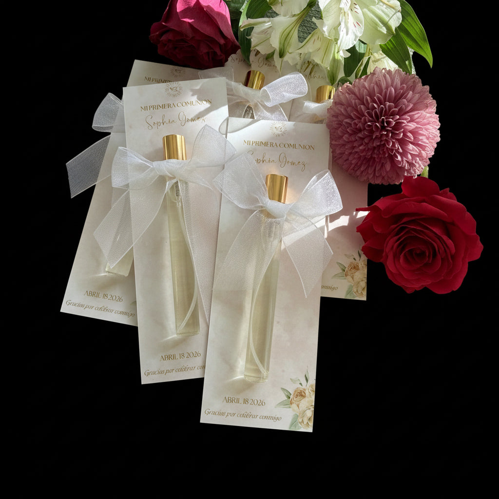 Small perfume bottles with gold caps on decorative cards, surrounded by flowers.