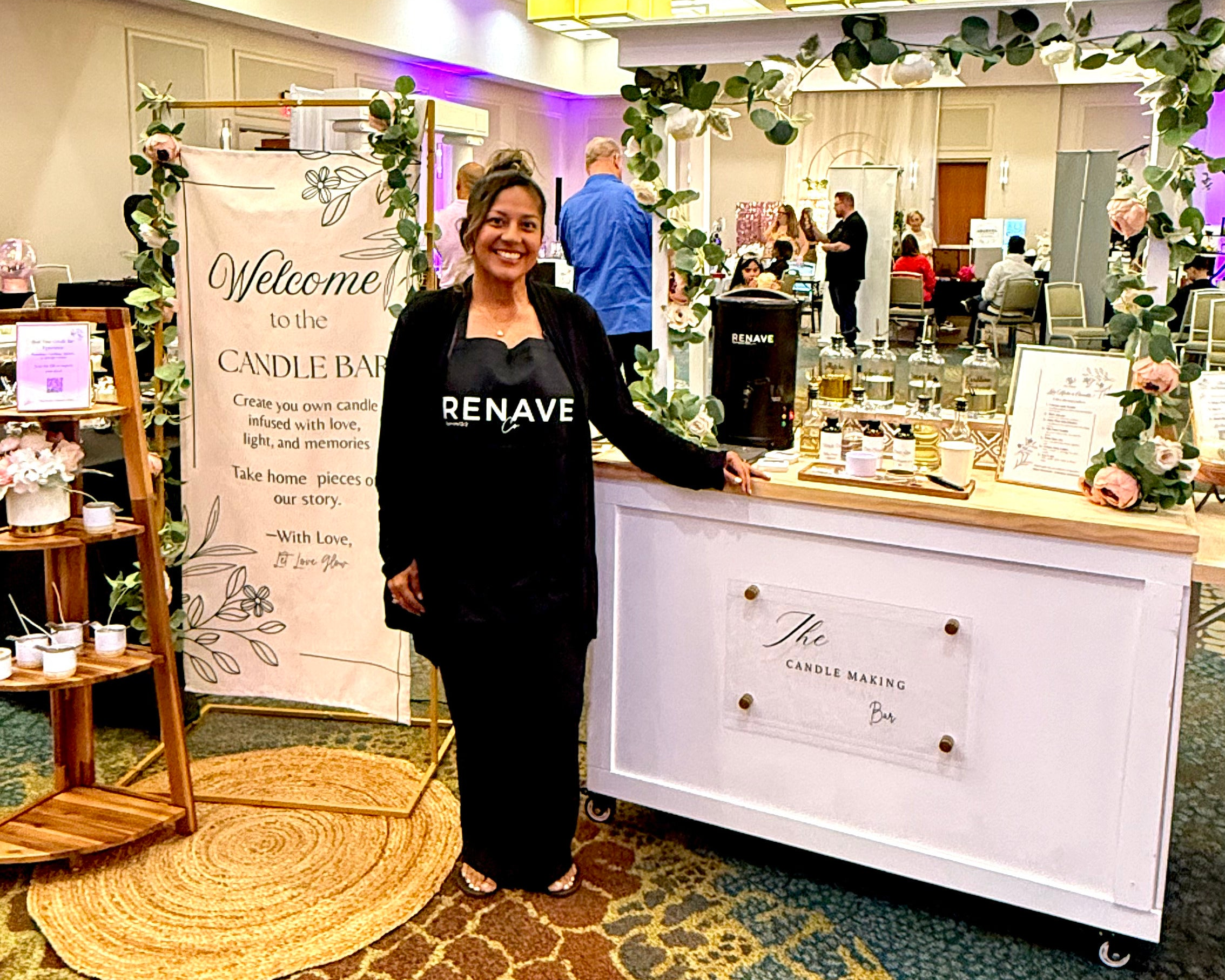 Woman standing in a store with a counter and products, wearing a black outfit with 'Renave' branding.